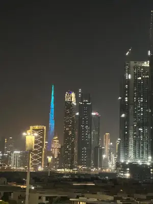 a city skyline at night with blue lighted buildings at Burj Khalifa View Ideal for Families in Dubai