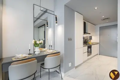 a kitchen and dining room with a table and chairs at Vogue Downtown Mag 318 near Burj Khalifa and Dubai Mall, Studio Apartment with Balcony, Canal and City Skyline View, Access to all Amenities in Dubai
