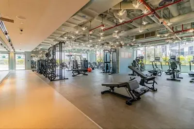 a gym with several treadmills and exercise machines at Vogue Downtown Mag 318 near Burj Khalifa and Dubai Mall, Studio Apartment with Balcony, Canal and City Skyline View, Access to all Amenities in Dubai