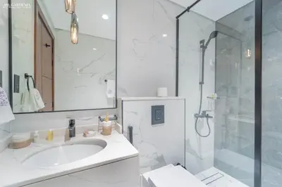 a white bathroom with a sink and a shower at Near Museum of the Future - Homey Apartment-Jumeirah Garden in Dubai