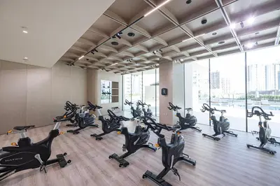 a gym with a bunch of exercise bikes at Luxury Binghatti Phantom Suites By Hostiva in Dubai