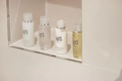 four white bottles on a shelf in a bathroom at Coastal Hideaway in La Mer - Beach Access and Burj View in Dubai