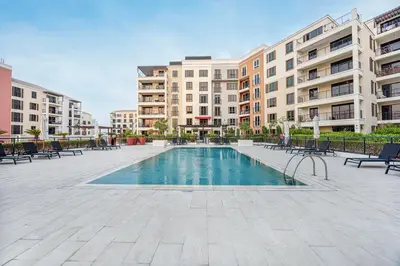 a swimming pool in the middle of a courtyard with buildings at Coastal Hideaway in La Mer - Beach Access and Burj View in Dubai