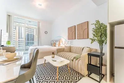a living room with a couch and a table at Charming Studio, Easy Access to Beach - Botanica Tower, Dubai Marina by Deluxe Holiday Homes in Dubai