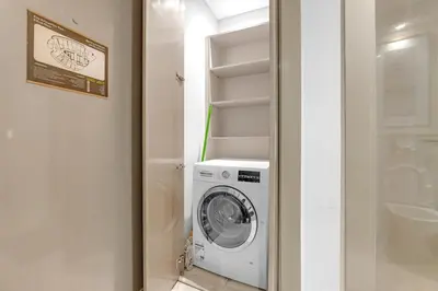 a washer and dryer in a small bathroom at Burj Khalifa View - Luxurious 1BHK in Business Bay in Dubai