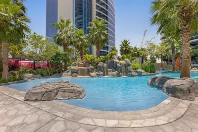 a large swimming pool with rocks in a city at Burj Khalifa View - Luxurious 1BHK in Business Bay in Dubai