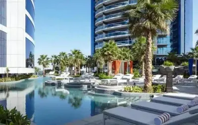a resort with a pool and palm trees and a building at Burj Khalifa View - Luxurious 1BHK in Business Bay in Dubai