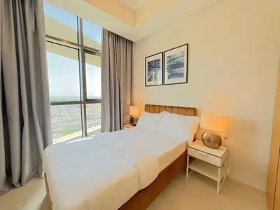 a bedroom with a bed and a large window at Cozy 2BHK - Sea View in Dubai