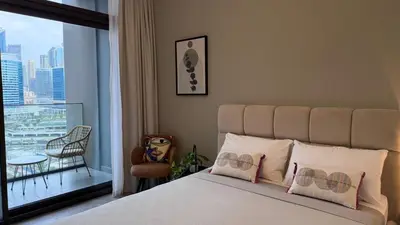 a bedroom with a bed and a large window at Stylish Studio Apartment in Peninsula 1 in Dubai
