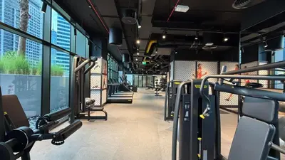 a gym with rows of treadmills and machines at Stylish Studio Apartment in Peninsula 1 in Dubai