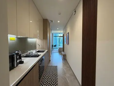 a kitchen with a stove and a counter top at Stylish Studio Apartment in Peninsula 1 in Dubai