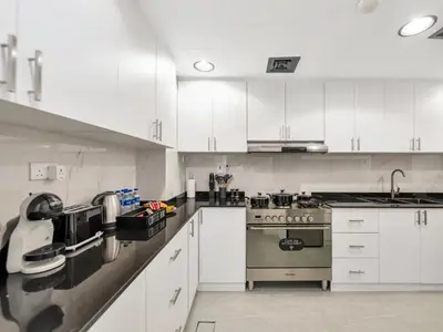 a kitchen with white cabinets and a stove at 4 BHK JBR BEACHFRONT# Next to Dubai Eye# Marina View in Dubai
