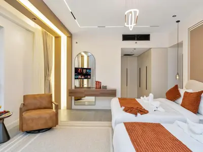 a hotel room with two beds and a chair at 4 BHK JBR BEACHFRONT# Next to Dubai Eye# Marina View in Dubai