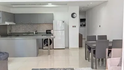 a kitchen and dining room with a table and a refrigerator at Superb Marina Views, Entire 1BR Apartment - Atlantic Towers next to Marina Mall in Dubai