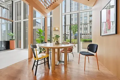 a dining room with a table and chairs and windows at Socio Tower Apt - Parking, Balcony&Pool - by Rentujemy in Dubai