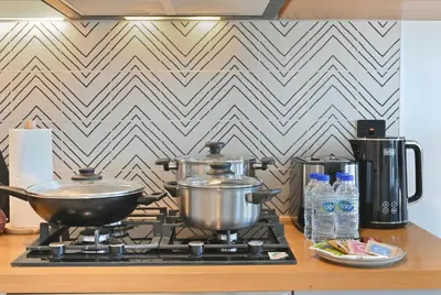a stove with pots and pans on top of it at Socio Tower Apt - Parking, Balcony&Pool - by Rentujemy in Dubai