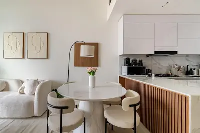 a kitchen with a table and chairs in a room at Cozy and Stylish 1BR in JVC in Dubai