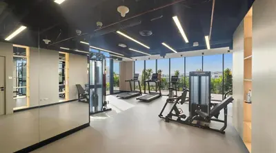 a gym with treadmills and ellipticals and windows at Luxury Studio in Dubai in Dubai