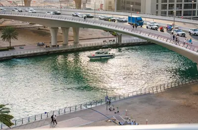 a bridge over a river with a boat on it at New 2BR in Dubai Marina - JBR & Marina View in Dubai
