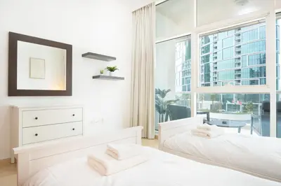 two beds in a bedroom with a large window at New 2BR in Dubai Marina - JBR & Marina View in Dubai