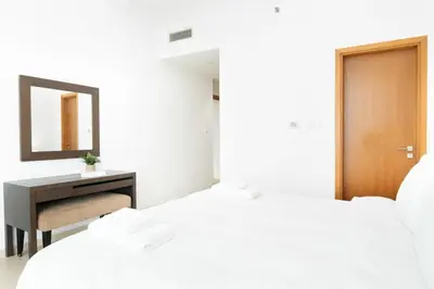 a bedroom with two beds and a desk and a mirror at New 2BR in Dubai Marina - JBR & Marina View in Dubai