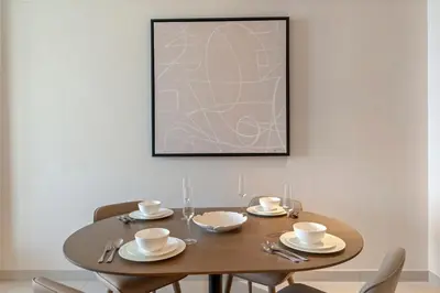a dining room table with two chairs and a picture at Vida Residences Dubai Mall Spacious 1BR Apartment in Dubai
