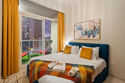 a bedroom with a bed and a large window at Fireworks Burj Khalifa View - One bedroom Apartment in Dubai