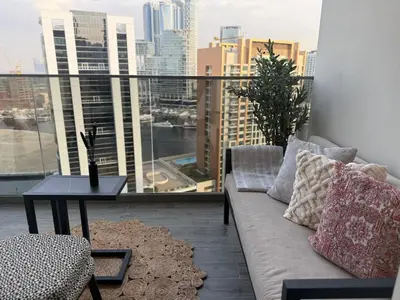 a couch on a balcony with a view of a city at MAG 318 Luxury Studio Resort Style Amenities in Dubai