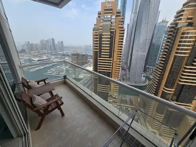 a balcony with a chair and a view of a city at Stunning 1-Bedroom Apartment in Botanica Tower in Dubai