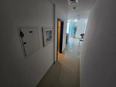 a hallway with white walls and a white door at Stunning 1-Bedroom Apartment in Botanica Tower in Dubai