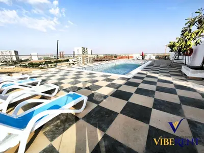 a pool on top of a building with a checkered floor at 2BHK near Expo, Al Maktoum Airport, Rooftop Pool in Dubai