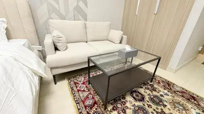 a living room with a couch and a coffee table at Luxure Studio with Pool View in Dubai