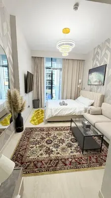a living room with a bed and a couch at Luxure Studio with Pool View in Dubai