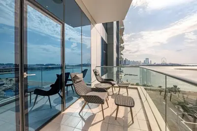 a balcony with chairs and a view of the water at Waves - Grand Palm Escape - Sea-View Massive 1BR Luxury in Dubai
