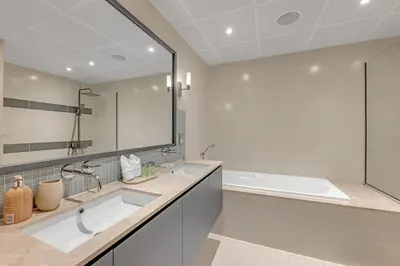 a bathroom with two sinks and a tub and a large mirror at Waves - Grand Palm Escape - Sea-View Massive 1BR Luxury in Dubai