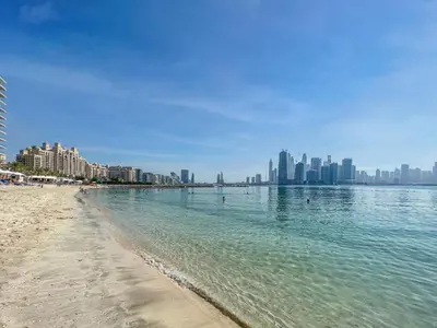 a view of a beach with a city in the background at Waves - Grand Palm Escape - Sea-View Massive 1BR Luxury in Dubai