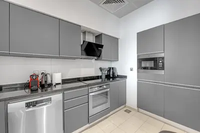 a kitchen with stainless steel appliances and white cabinets at Waves - Grand Palm Escape - Sea-View Massive 1BR Luxury in Dubai