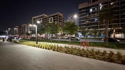 a city street at night with buildings and street lights at Luxury Studio in the Heart of Meydan in Dubai