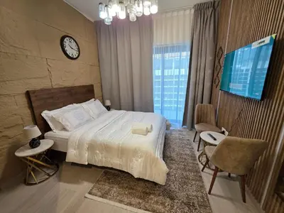 a bedroom with a bed and a clock on the wall at Luxury Studio in the Heart of Meydan in Dubai