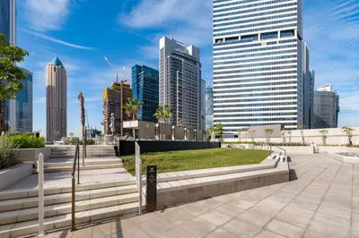 a park in a city with tall buildings at Luxury High-Floor Canal View near Burj Khalifa in Dubai