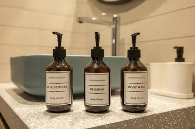 three bottles of soap sitting on a counter in a bathroom at Luxury High-Floor Canal View near Burj Khalifa in Dubai