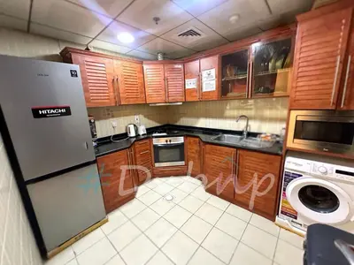 a kitchen with wooden cabinets and a washer and dryer at Prime Living Partition Room In Barsha Heights Tecom in Dubai