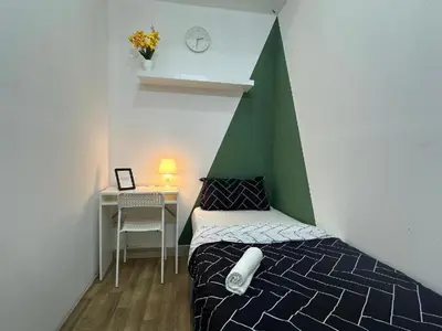 a bedroom with a bed and a table with a clock at Velvet Vault Partition Room In Barsha Heights Tecom in Dubai