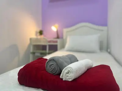 a bed with two towels on a red blanket at City Stay Partition Room in Barsha Heights tecom in Dubai