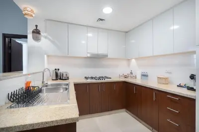 a kitchen with white cabinets and a sink at Premium 1BR in Downtown & Direct Access to Metro in Dubai