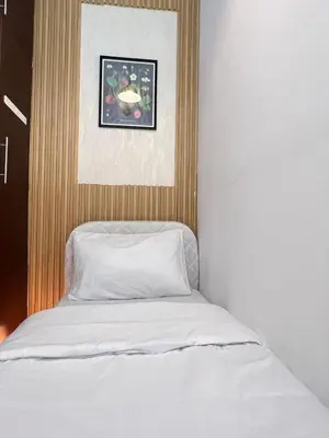 a bed with white sheets and a picture above it at Affordable Partition Room In Barsha Heights Tecom in Dubai