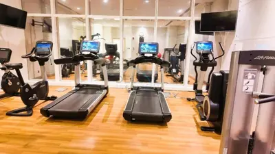 a gym with several tread machines in a room at High-Floor 3BR with Balcony Overlooking the Marina, Near the Beach, Just Minutes Walk to the Tram, Damac Heights, Dubai Marina by Deluxe Holiday Homes in Dubai