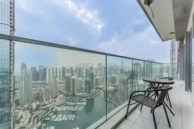 a balcony with a table and chair on a building at High-Floor 3BR with Balcony Overlooking the Marina, Near the Beach, Just Minutes Walk to the Tram, Damac Heights, Dubai Marina by Deluxe Holiday Homes in Dubai