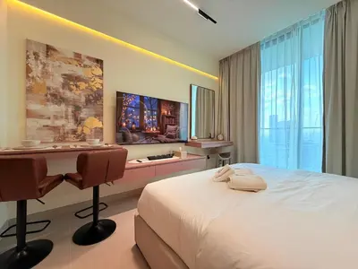 a hotel room with a bed and a desk and a table at Mahenti - Stylish Urban Studio with Burj View in Dubai