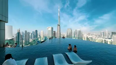 a infinity pool with a view of a city at Premium 3BR Paramount Hotel Midtown Business Bay in Dubai